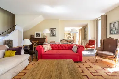 a living room with a red couch and chairs at Les Deux Mas in Lagnes