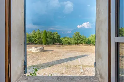 a view of a field through a window at Maison Sebastien in Saint-Michel-lʼObservatoire