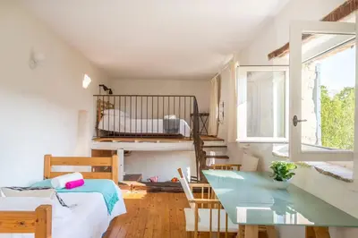 a room with a bed and a glass table at Maison Sebastien in Saint-Michel-lʼObservatoire