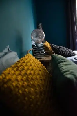 a close up of a bed with a blanket and a lamp at Une pause en Provence au Village des antiquaires de la Gare in LʼIsle-sur-la-Sorgue