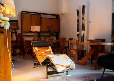 a living room with a chair and tables and chairs at Une pause en Provence au Village des antiquaires de la Gare in LʼIsle-sur-la-Sorgue
