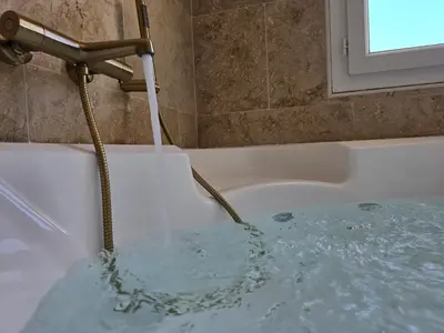 a stream of water coming out of a bath tub at Pic love, 2 personnes jacuzzi in Châteaurenard