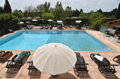 a pool with a white umbrella and chairs at Camping 4 étoiles - Piscine - eehf0d in Noves