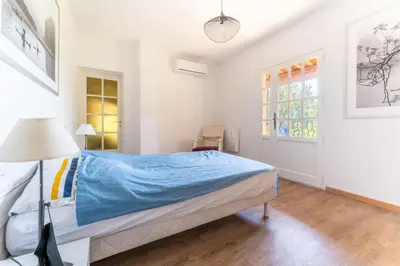 a bedroom with a bed with blue sheets and a lamp at Provencal bastide with heated pool near Alpilles and Luberon in Vernègues