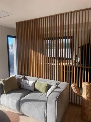 a gray couch in a room with a large window at Gîte Un air de Provence in Eyguières