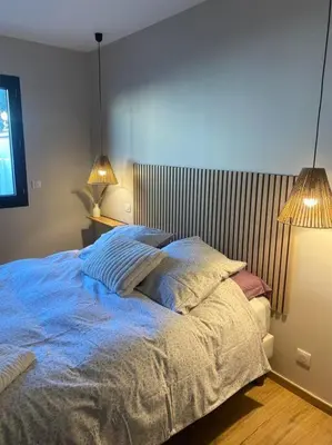 a bedroom with a bed with blue sheets and two lamps at Gîte Un air de Provence in Eyguières
