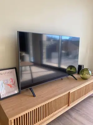 a flat screen tv sitting on top of a wooden shelf at Gîte Un air de Provence in Eyguières