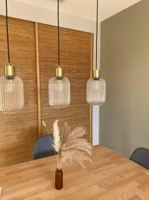 a dining room with a table with a vase with feathers at Gîte Un air de Provence in Eyguières