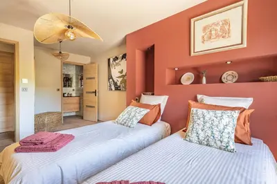 two beds in a room with red walls at KM2 in Bédoin