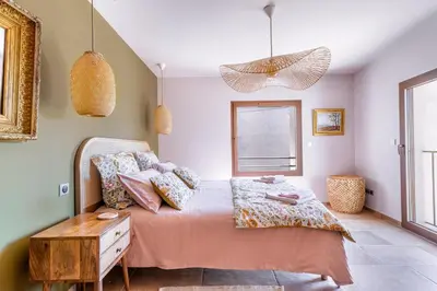 a bedroom with a bed with pink sheets and pillows at KM2 in Bédoin