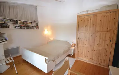 a bedroom with a white bed and a wooden cabinet at 1 Bedroom Lovely Home In Viens in Viens