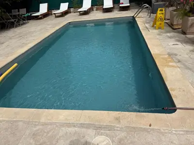 a swimming pool with blue water and chairs at Charmant studio le clos d'Aix parking privé gratuit et piscine in Aix-en-Provence