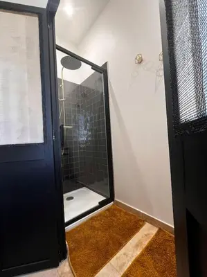 a bathroom with a shower with a glass door at Le Platane Maison climatisée avec piscine in Monteux