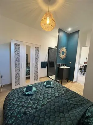 a bedroom with a large bed with a green blanket at Le Platane Maison climatisée avec piscine in Monteux