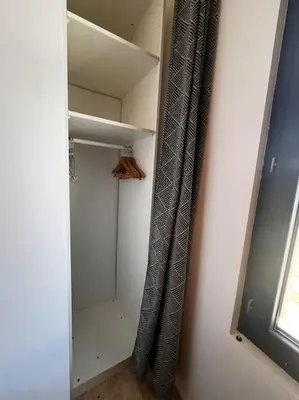 a walk in closet with a curtain and a window at Le Platane Maison climatisée avec piscine in Monteux