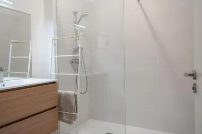 a white bathroom with a shower and a sink at T3 Centre ville Aix-en-Provence in Aix-en-Provence