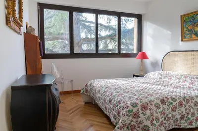 a bedroom with a bed and two windows at T3 Centre ville Aix-en-Provence in Aix-en-Provence