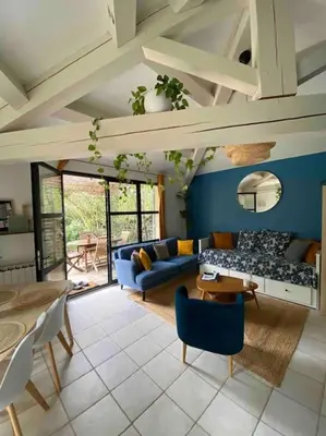 a living room with a couch and a table at Charmante dépendance avec piscine en Provence in Le Puy-Sainte-Réparade