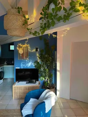 a living room with a blue chair and a tv at Charmante dépendance avec piscine en Provence in Le Puy-Sainte-Réparade