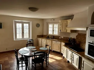 a kitchen with a table and chairs in a kitchen at Domaine des Figons in Éguilles