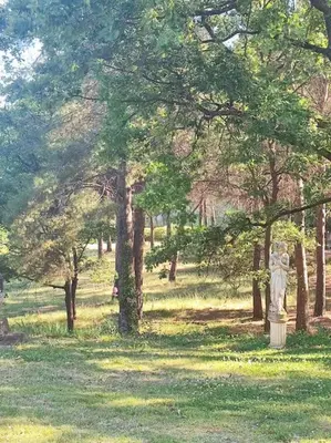a statue in the middle of a field with trees at Domaine des Figons in Éguilles