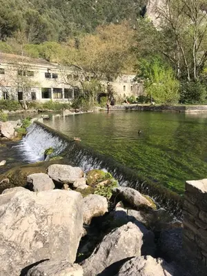 a river with rocks and people in the water at Le Mas Mérindol Gîte Cerise in Loriol-du-Comtat