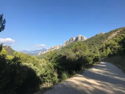 a dirt road with a mountain in the background at Le Mas Mérindol Gîte Cerise in Loriol-du-Comtat
