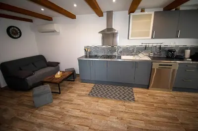 a kitchen with a couch and a table in a room at Appartement moderne à Avignon avec piscine partagée in Avignon