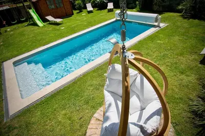 a swing in a yard next to a swimming pool at Maison conviviale avec jardin proche Avignon + piscine partagée in Avignon