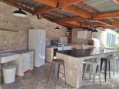a kitchen with a counter and a refrigerator at Maison conviviale avec jardin proche Avignon + piscine partagée in Avignon