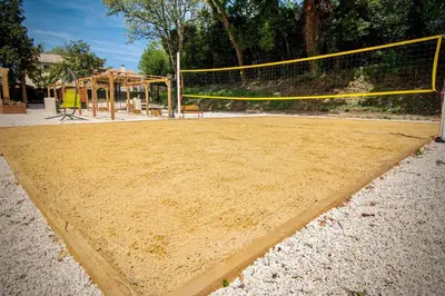 a volley ball court with a net and a playground at Maison conviviale avec jardin proche Avignon + piscine partagée in Avignon