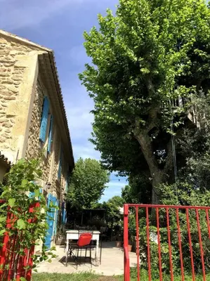 a red fence next to a table and a tree at Superbe mas proche centre-ville in Salon-de-Provence
