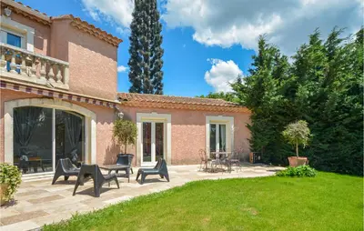 a patio with chairs and tables in front of a house at Nice Home In Eyguieres With Wifi in Eyguières