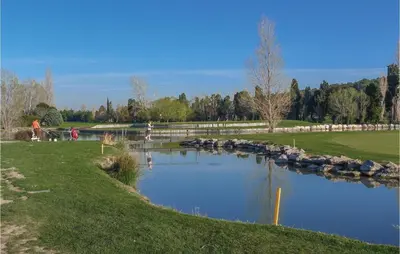 a pond in a park with people standing around it at Nice Home In Eyguieres With Wifi in Eyguières