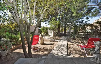 two red chairs sitting in the shade of trees at Nice Home In Saint Cannat With Wifi in Saint-Cannat