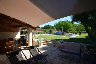 a patio with chairs and a table and a yard at La maison d'Anthonie, Roussillon in Roussillon