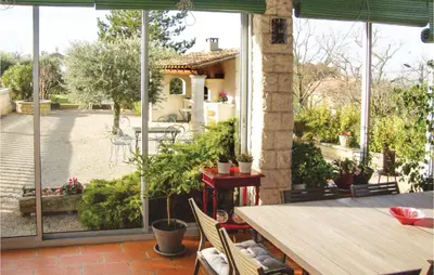 a patio with a table and a view of a courtyard at La Maoure in Robion en Luberon