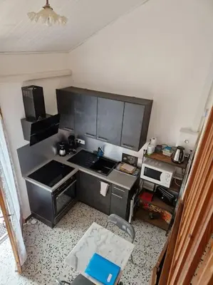 an overhead view of a small kitchen with a stove at Gîte Le Val des Fées classés deux étoiles in Roussillon