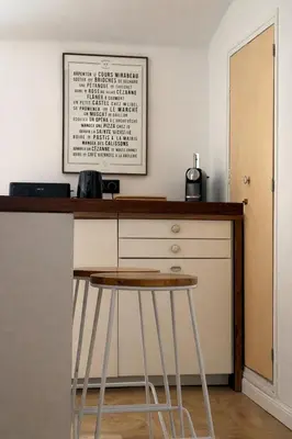 a bar with a stool and a picture on the wall at Petit Cocon avec Vue Dernier Etage - Mazarin 1833 in Aix-en-Provence