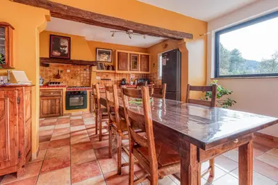 a kitchen with a large wooden table and chairs at La Maison du Chapelier in Fontaine-de-Vaucluse