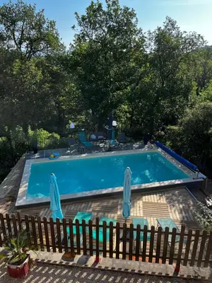 a swimming pool with two chairs and a fence at La Bastide de Mauragne - Gîte Les Pivoines in Apt