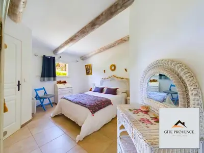 a bedroom with a bed and a table in it at Gîte de la Draillette in Noves