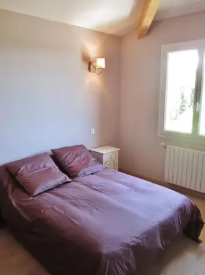 a bedroom with a purple bed with a window at appartement T3 dans propriété de 5000m2 avec piscine in Venelles