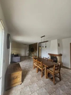 a living room with a wooden table and chairs at La villa Li Grihet in Beaumont-de-Pertuis