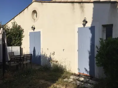 a white building with two white doors and a bench at LES VIEUX CABASSOLS VENELLES in Venelles