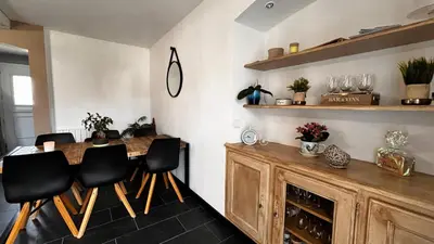 a dining room with a wooden table and black chairs at Chez Jenn- Jolie maison climatisée avec piscine in Monteux