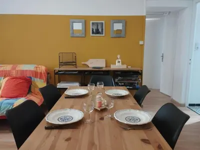 a dining room table with plates and glasses on it at Appartement en plein centre. in Carpentras
