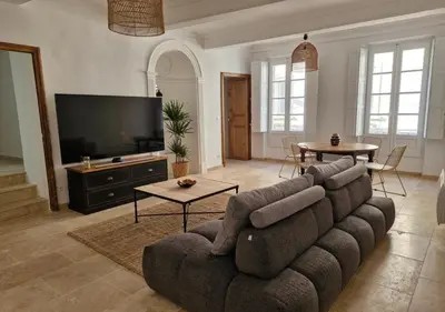 a living room with a couch and a flat screen tv at Appartement de caractère - CARPENTRAS - Rendez-vous en Provence in Carpentras