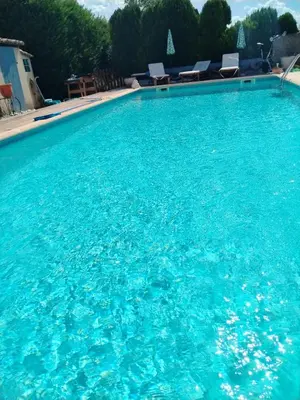 a large blue swimming pool with blue water at Lou Jasset in Cabrières-dʼAigues