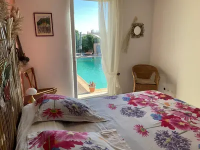 a bedroom with a bed with a view of a pool at Lou Jasset in Cabrières-dʼAigues